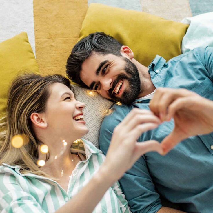 A happy couple having fun in the living room after reading these quality time activities for couples