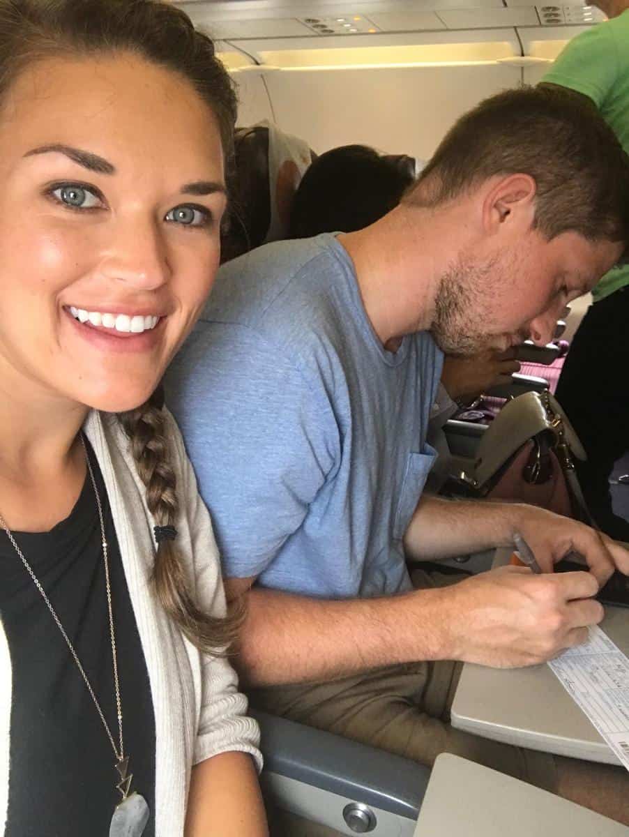 Couple filling out customs forms on a plane.
