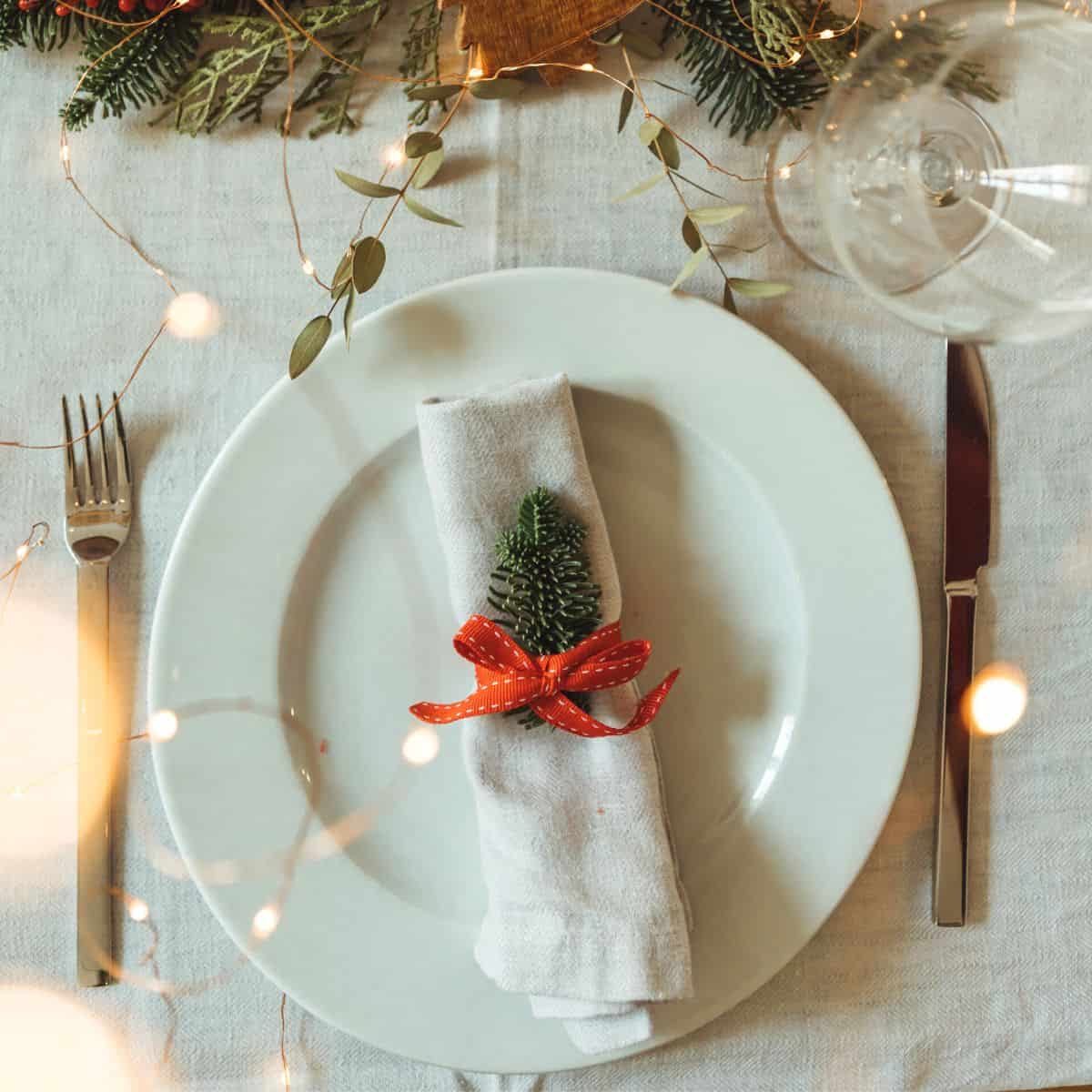 A table set with lovely Christmas ornaments and lights prepared after reading these Christmas dinner menu for two