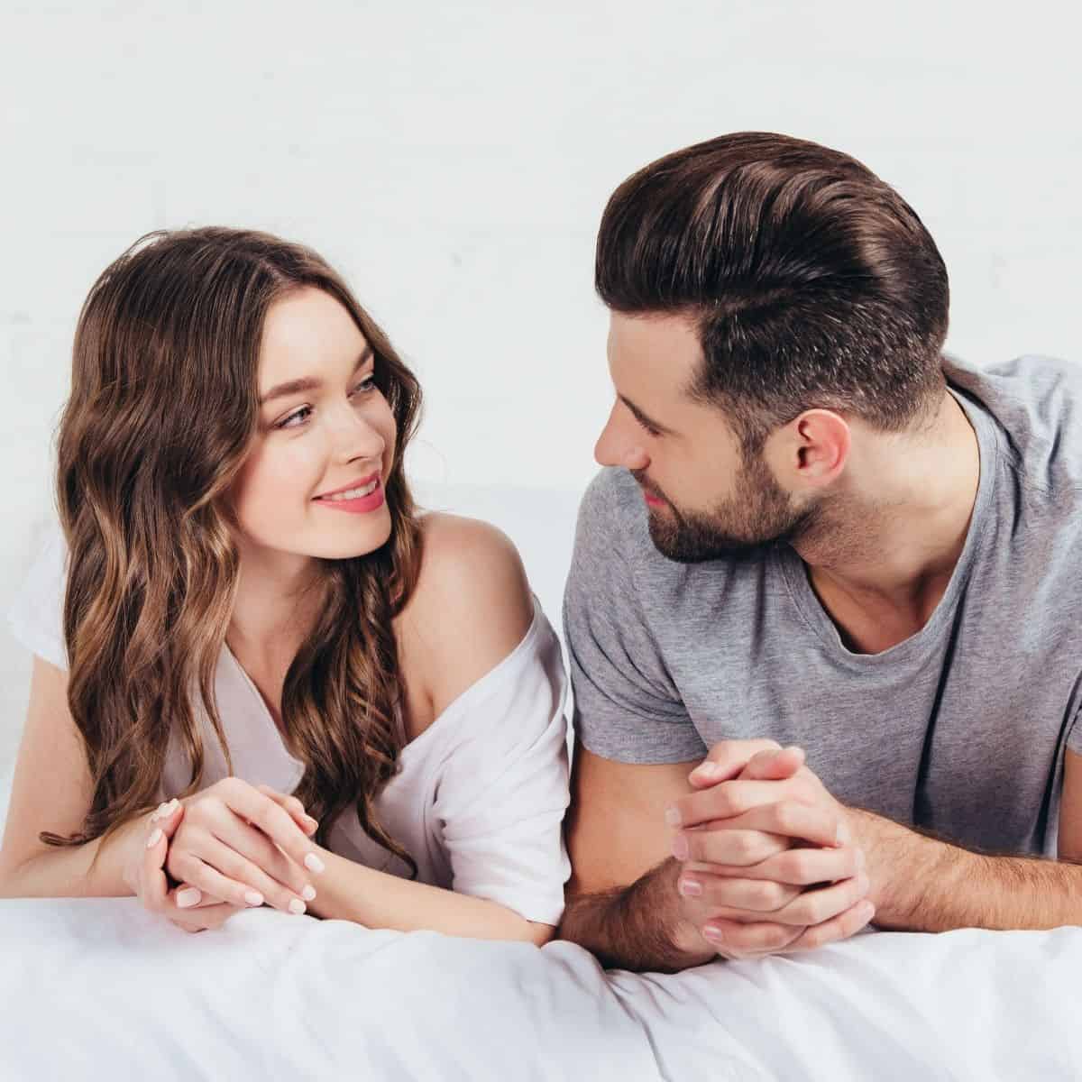 A couple on the bed asking each other questions to ask your spouse to reconnect