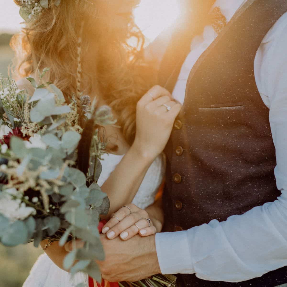 Close up of a bride and groom with the sun shining behind them.