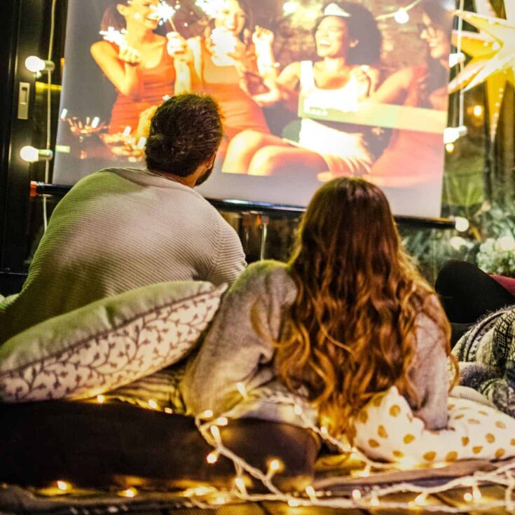 A lovely couple having a cozy backyard movie night together