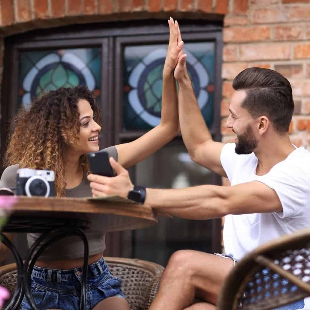A couple doing a high five while asking each other never have i ever questions for couples