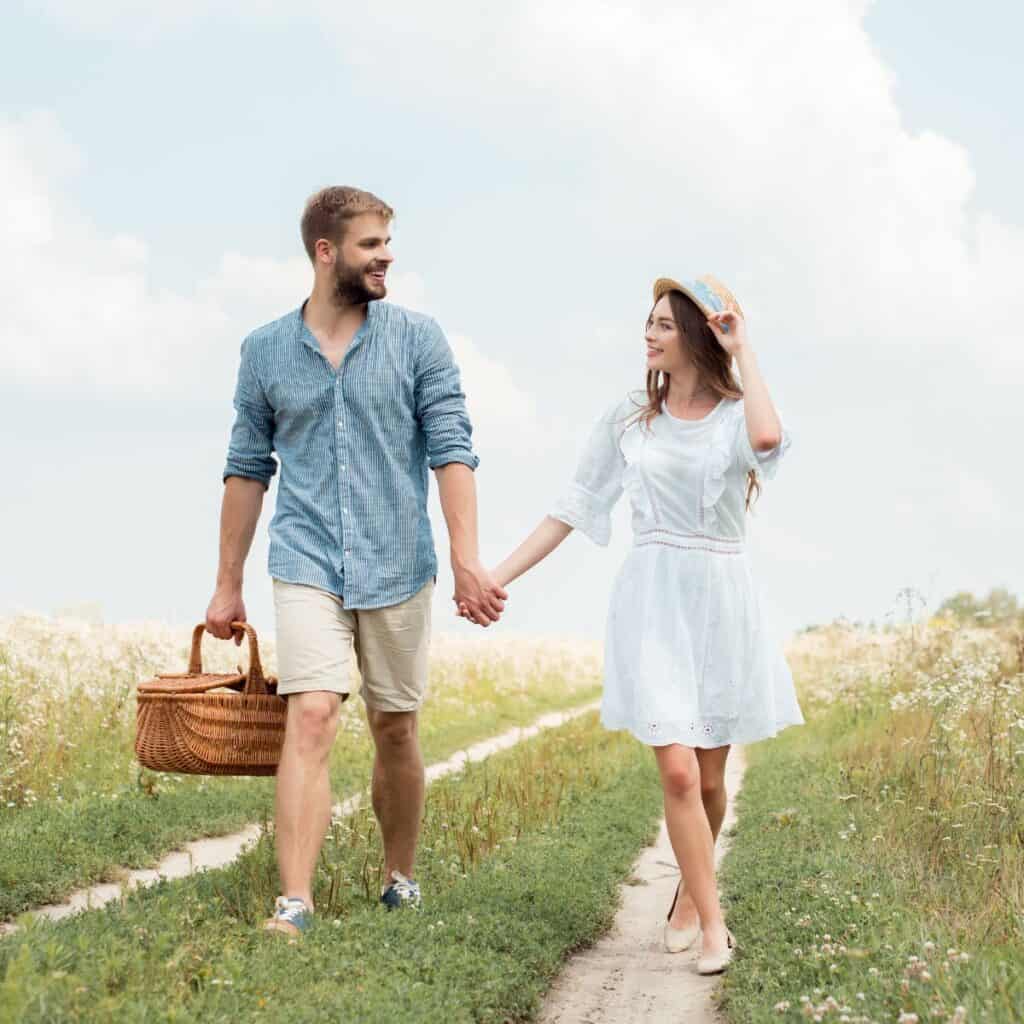 A couple walking together with a picnic basket to spend time together after reading these tips for a happy marriage