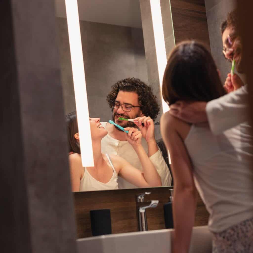 Couple brushing their teeth together.