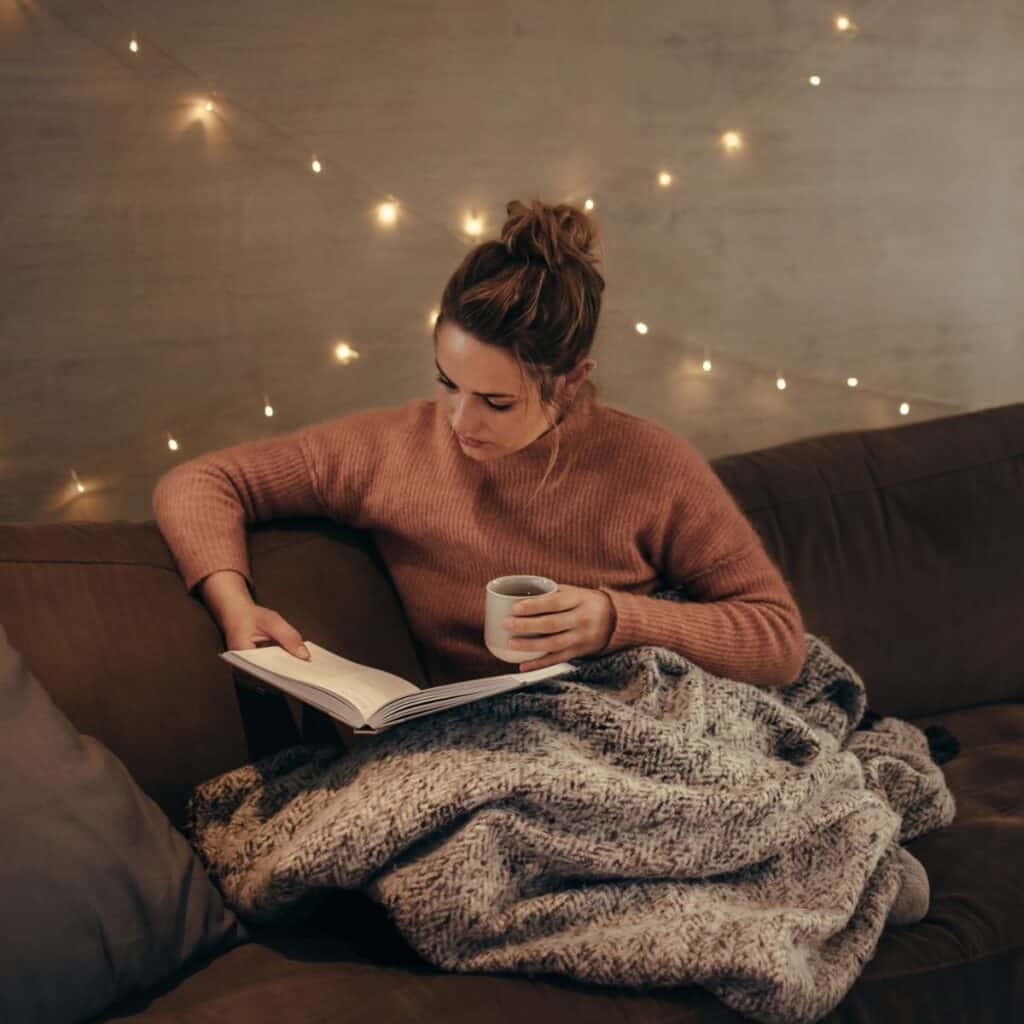Woman reading a book while sitting on the couch