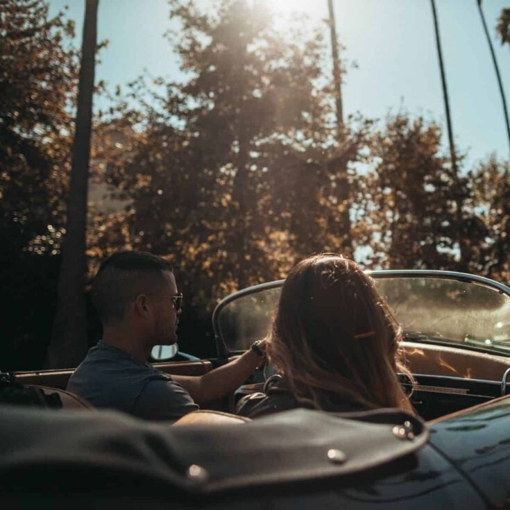 A couple in a car while asking each other road trip questions for couples