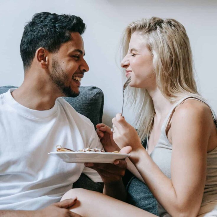 A happy couple eating together after reading these last minute date ideas