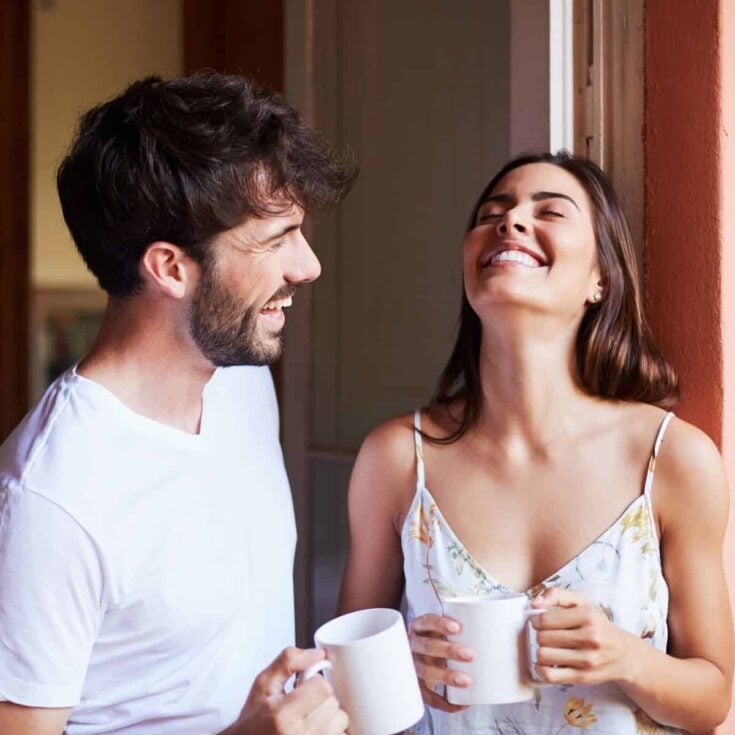 A couple having a happy morning while drinking coffee together after reading these morning date ideas