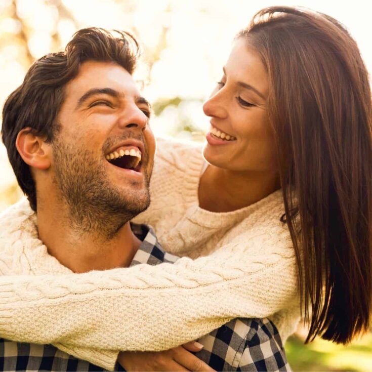 Laughing couple outside asking yes or no questions for couples.