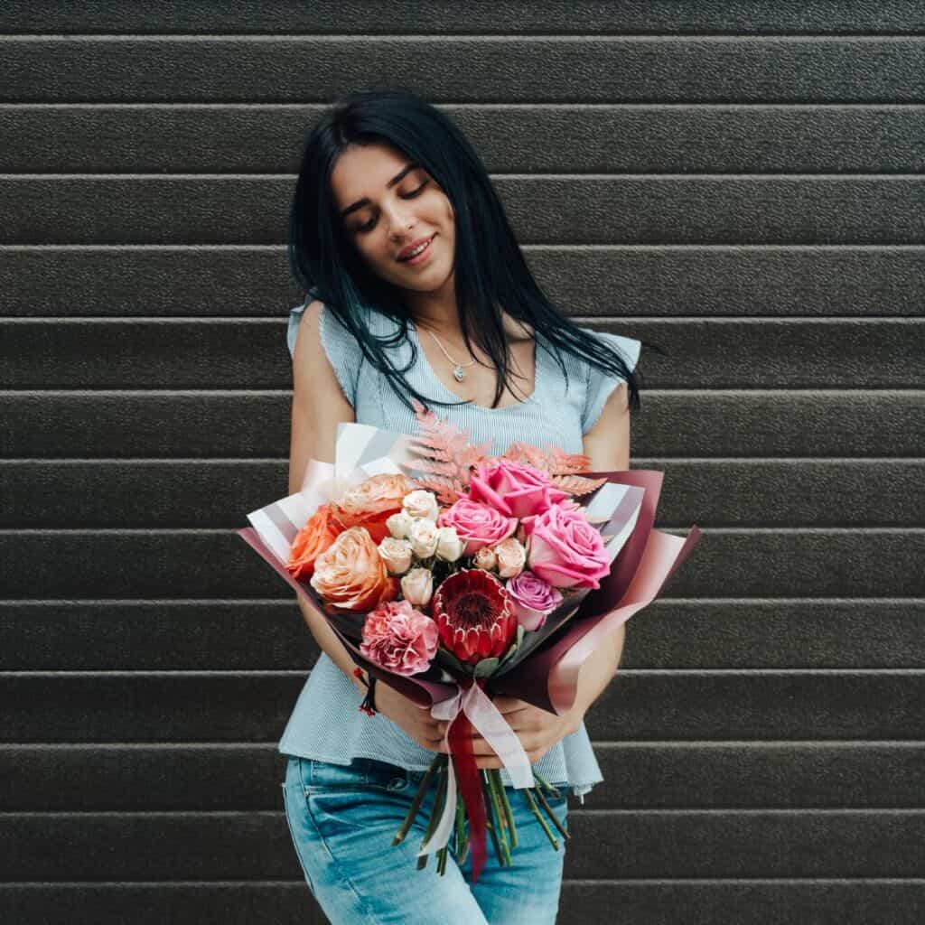 A girl holding her favorites after receiving it as an anniversary flowers