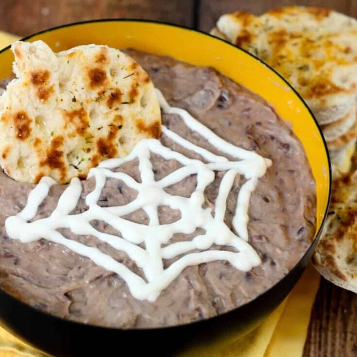 Curried black bean dip snack with a spider web design on top, prepared after reading these Halloween date ideas