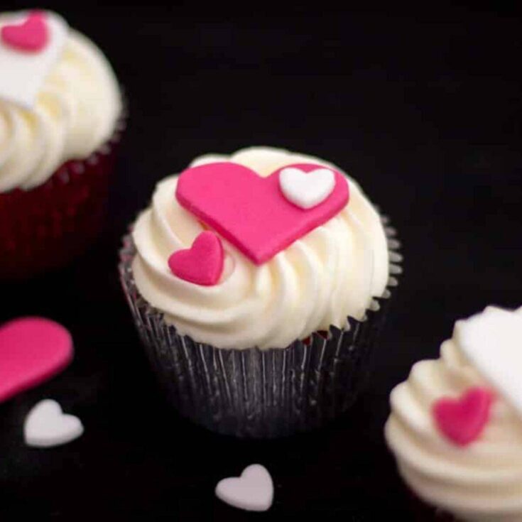 A set of red velvet Valentines Day cupcakes with heart toppings