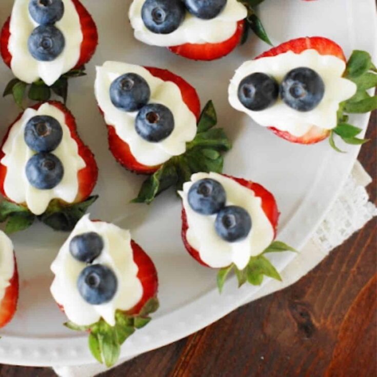 A plate of red, white, and blue strawberry cheesecake bites perfect for 4th of July breakfast ideas