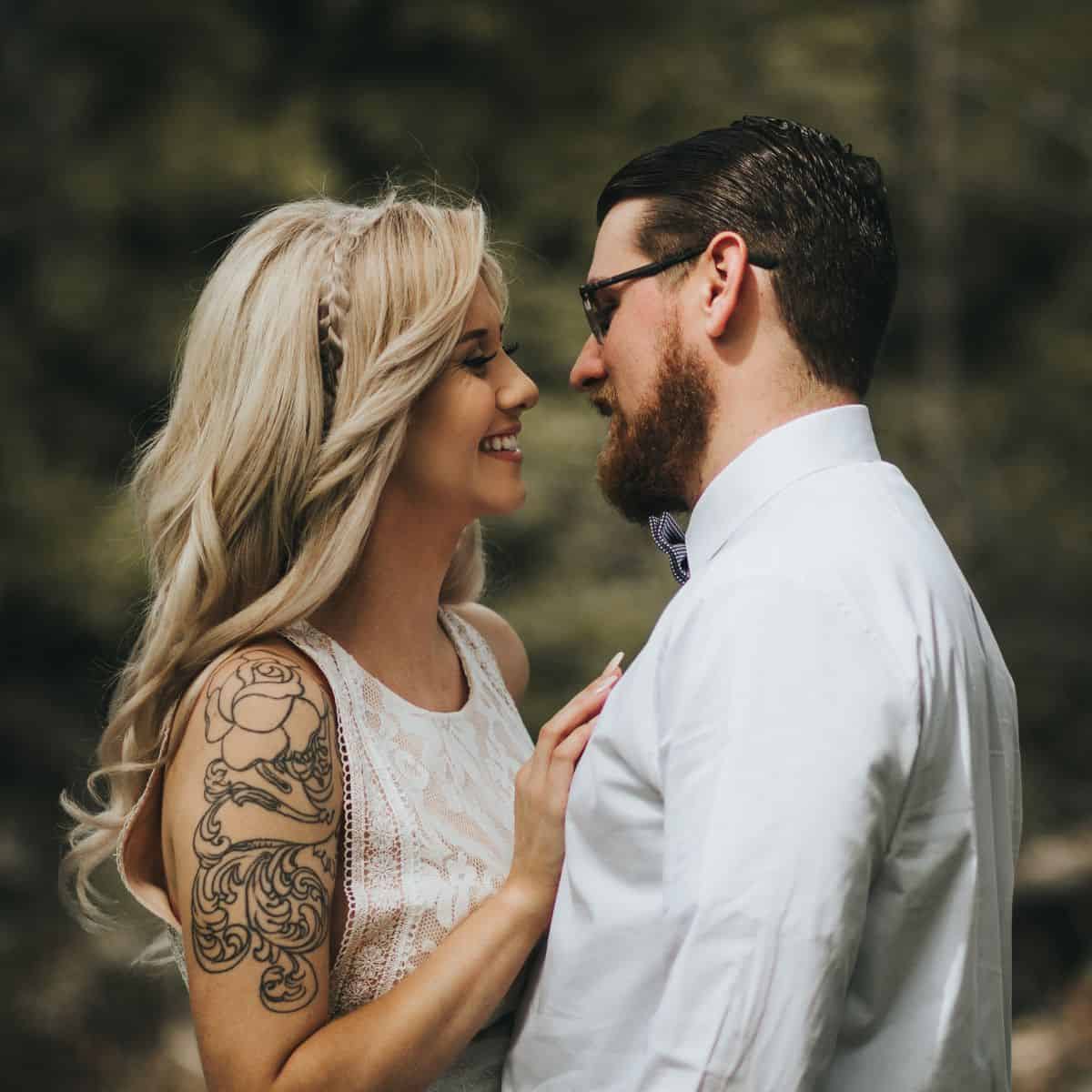 A couple with tattoos intimately facing each other