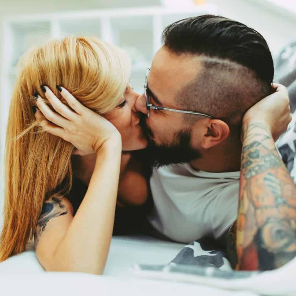 A tattooed couple kissing using tattoos as a form of self-expression