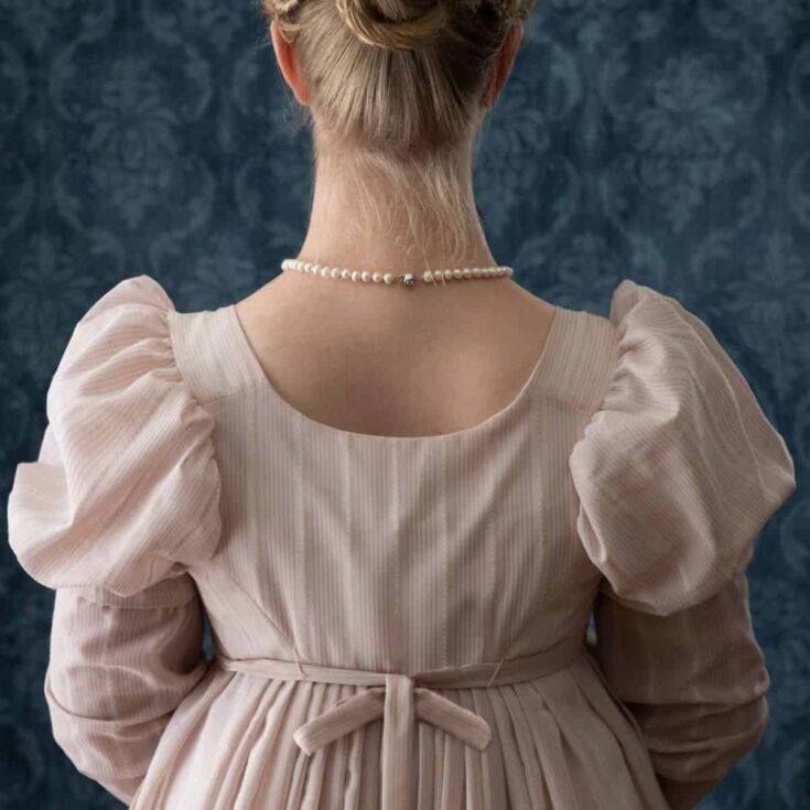 The back of a woman in a soft pink Regency dress (Jane Austen quotes about love)