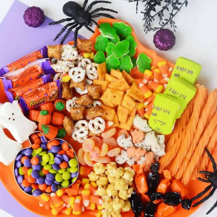 Halloween charcuterie board filled with candies, gummy bears, pretzels, and chocolates