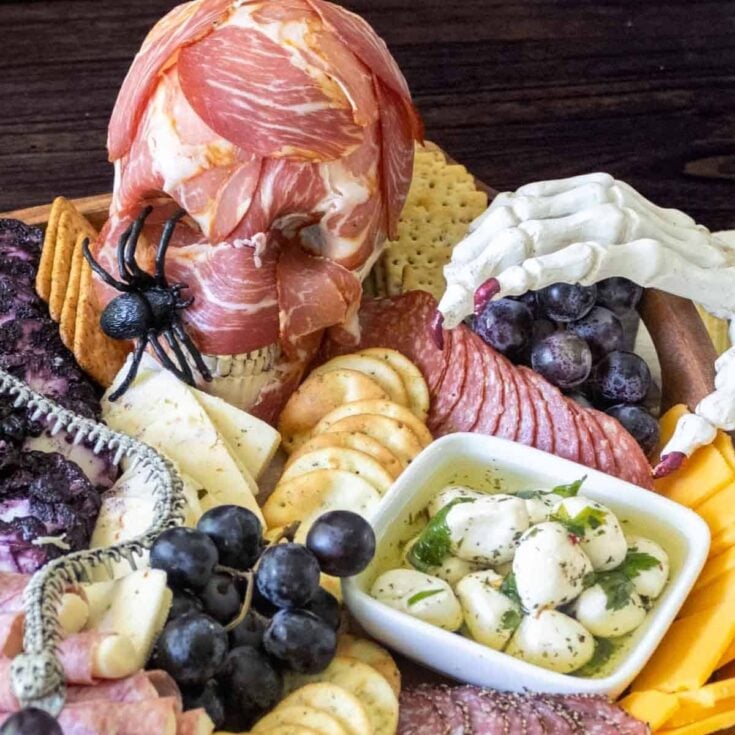 A Halloween charcuterie snack board with creepy skull and skeleton designs