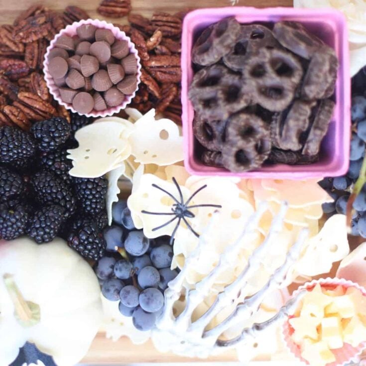 Halloween charcuterie board filled with chocolate, pretzels, blackberries, and more