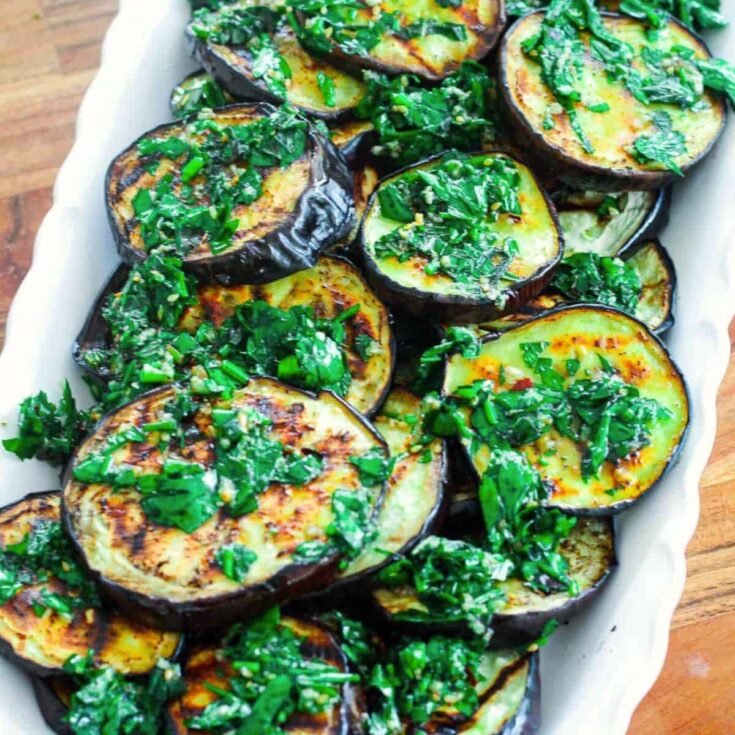 A tray of grilled eggplants with parsley mint and Za'atar sauce cookout sides