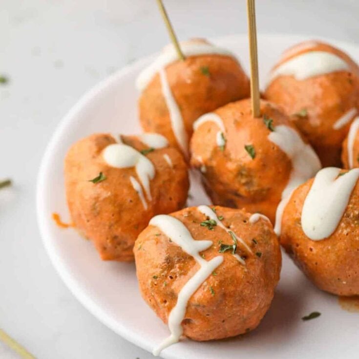 A plate of appetizing buffalo turkey meatballs, cooked after reading these Tailgating recipes