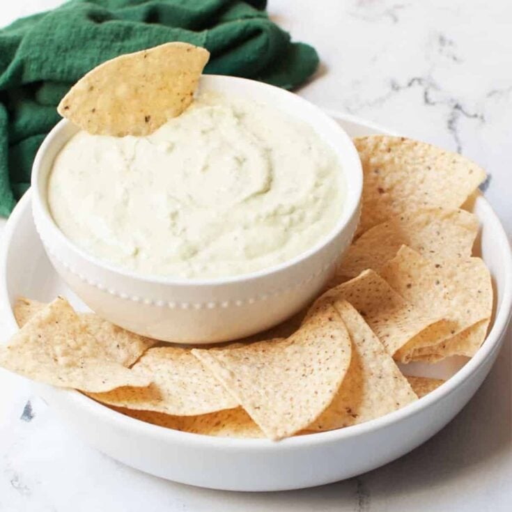 A bowl of creamy green avocado dip cooked after reading these Tailgating recipes