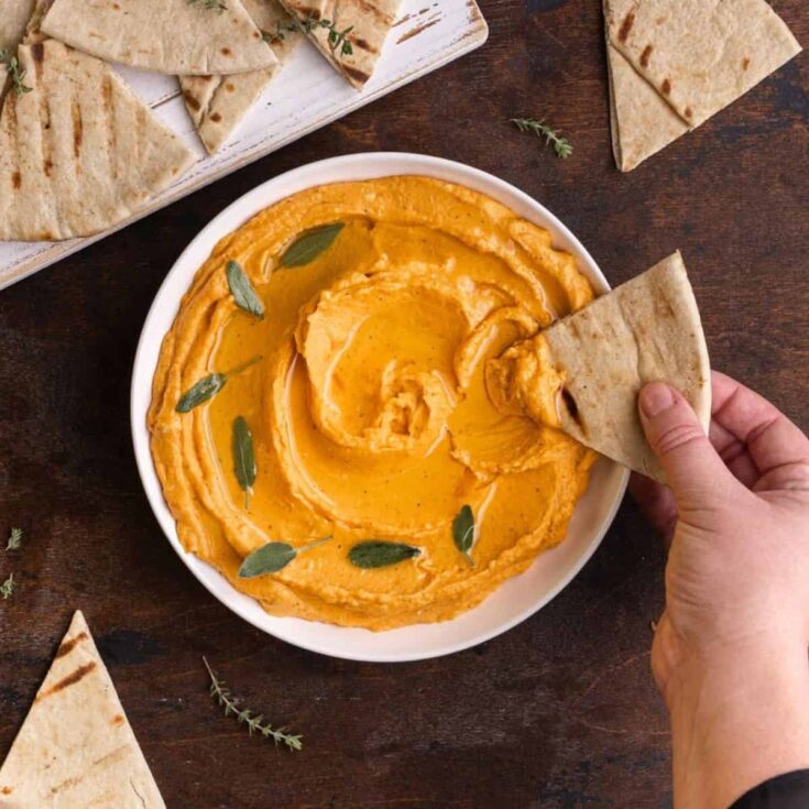 A bowl of creamy sweet potato hummus cooked after reading these Fall appetizers recipe