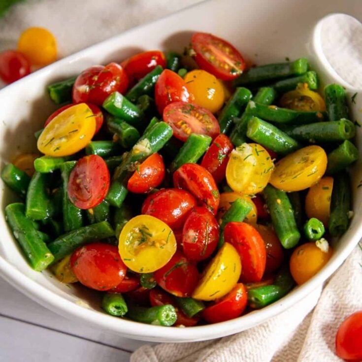 A bowl of an appetizing green bean and tomato salad, prepared after reading these summer salad recipes