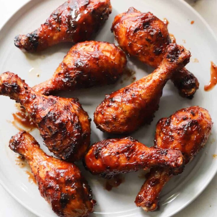 A plate of grilled BBQ chicken drumsticks cooked after reading these Summer grilling recipes