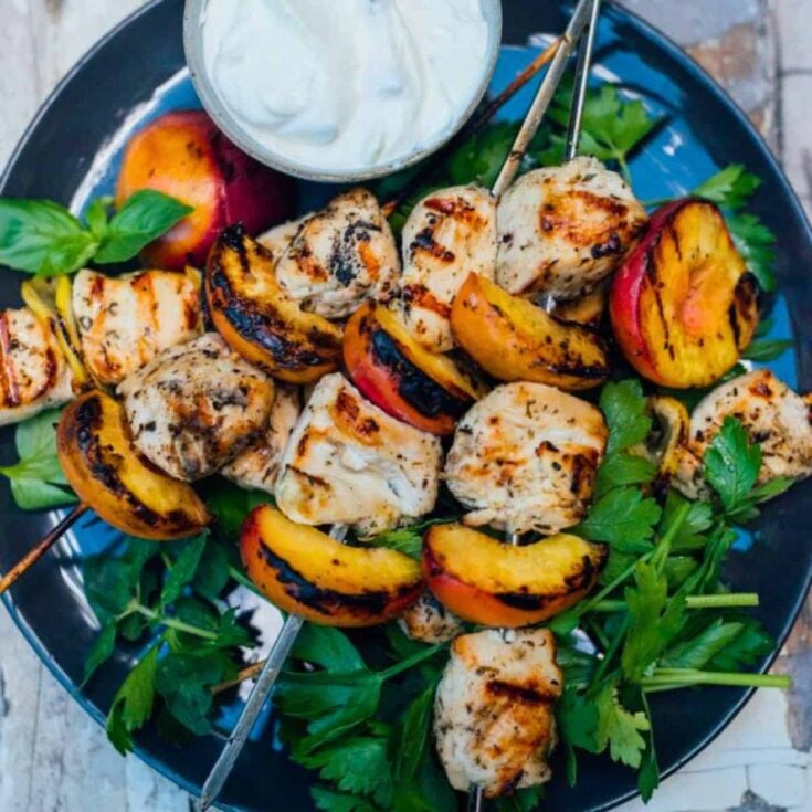 A plate of grilled peach and chicken kebabs cooked after reading these Summer grilling recipes