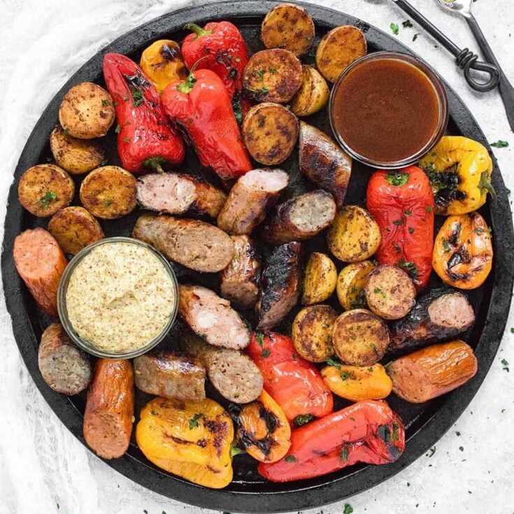 Grilled sausages, peppers and potatoes cooked after reading these Tailgating recipes