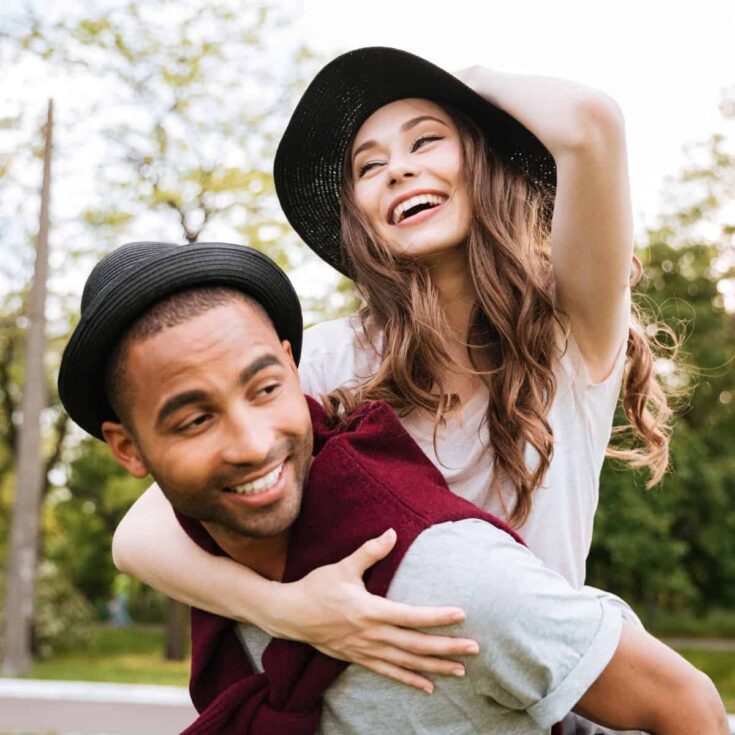 A happy couple on a piggy back ride, ready to fulfill all these alphabet dating ideas together