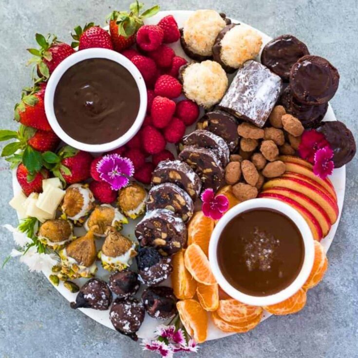 Chocolate dessert board filled with strawberries, apples, tangerines, chocolates and more, prepared after reading these Valentines charcuterie boards