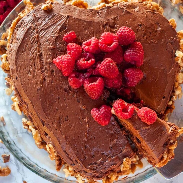 Chocolate sponge cake with walnuts topped with raspberries prepared after reading these Valentines day cake recipes