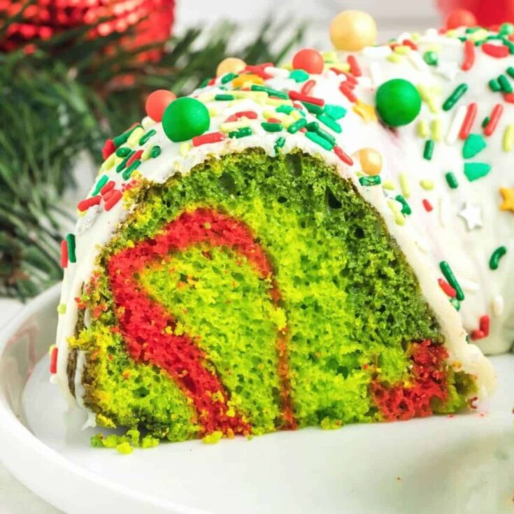 A slice of red and green cake, topped with sprinkles, baked after reading these Christmas Bundt cake recipe
