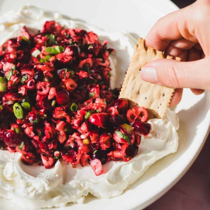 A plate of fresh cranberry jalapeno cream cheese dip prepared after reading these Christmas appetizers