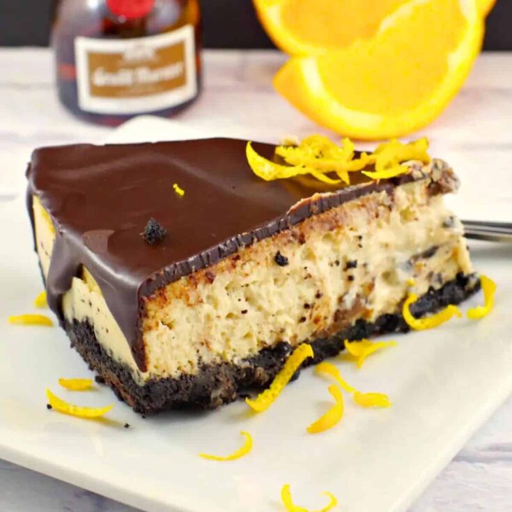 A slice of Grand Marnier cheesecake with chocolate glaze baked after reading these Chocolate Thanksgiving Desserts