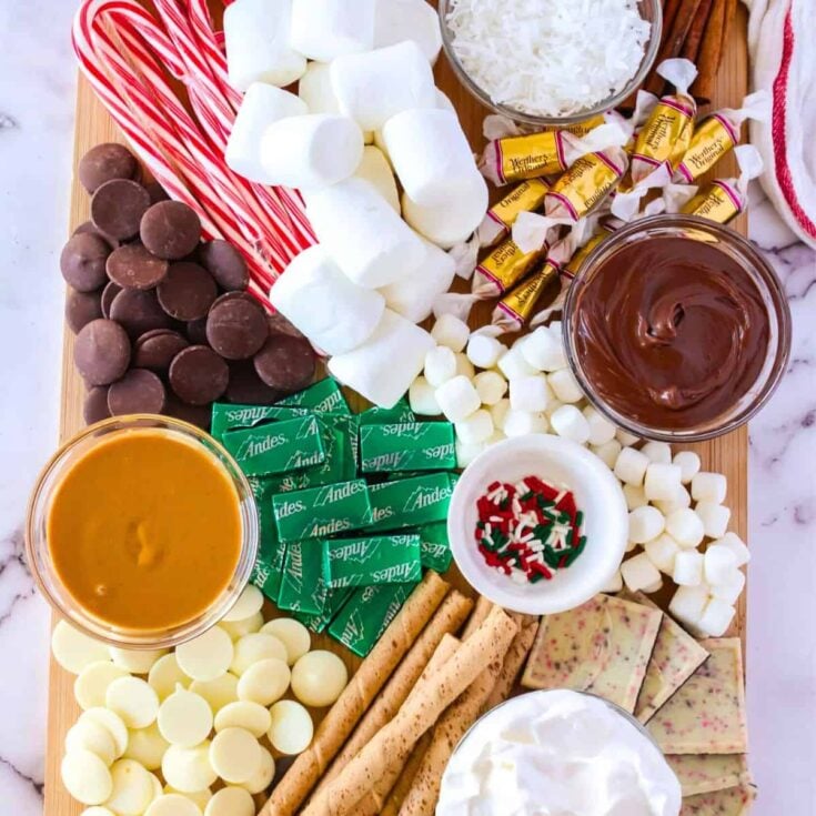 A board filled with marshmallows, chocolates, candy canes, and more, prepared after reading these Christmas charcuterie board