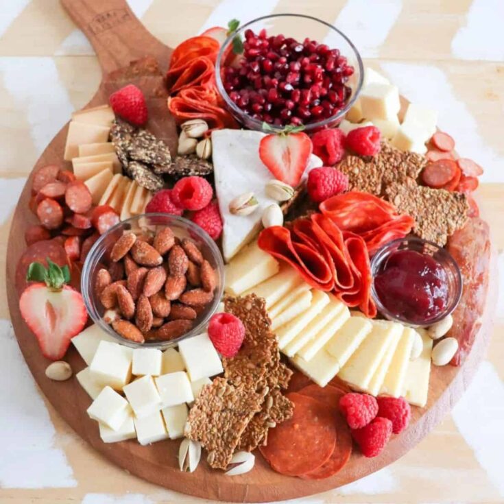 A keto Valentines charcuterie board filled with almonds, cheese, ham, strawberries, and more