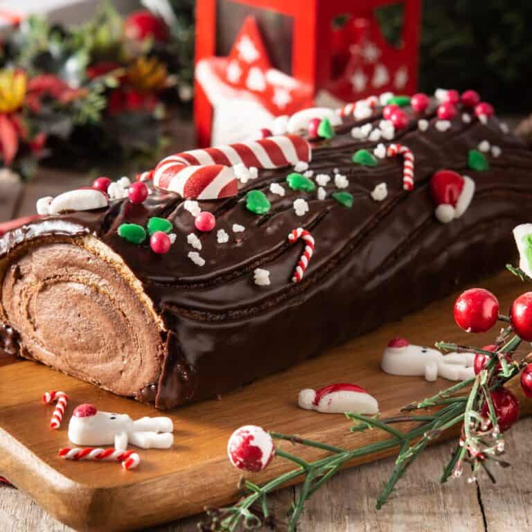 A Christmas log shaped cake, topped with candy canes, baked after reading these Christmas chocolate cake recipes