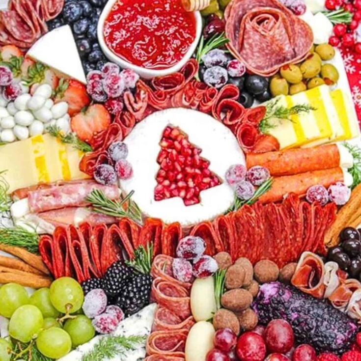 A charcuterie board filled with ham, cheese, berries, and more, prepared after reading these Christmas charcuterie board