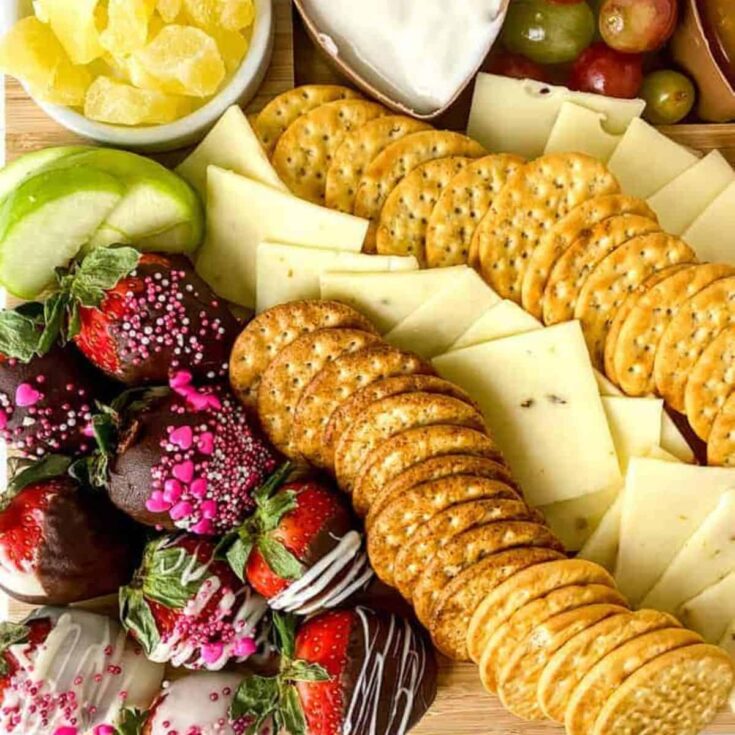 Valentines charcuterie dessert boards with biscuits, cheese, and chocolate coated strawberries