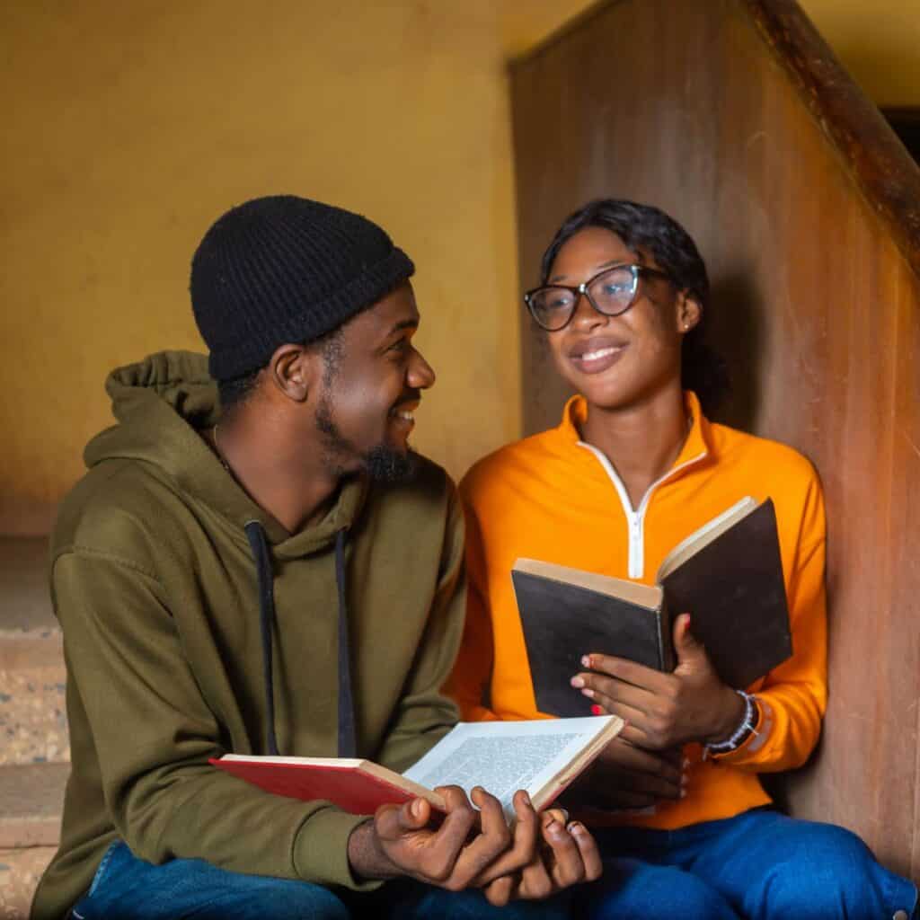 Teen couple at home, reading a book together after reading these fall date ideas for teens