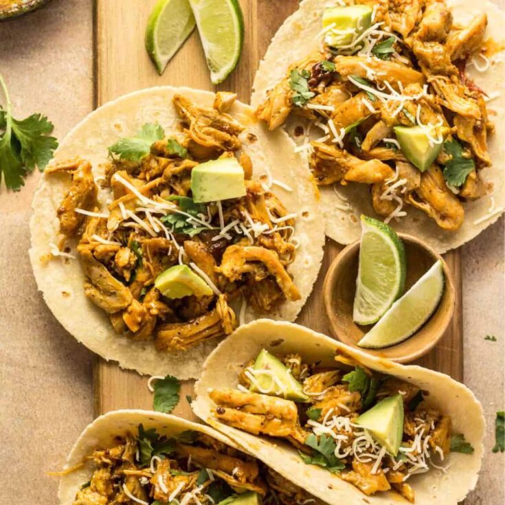 A set of Chipotle orange chicken tacos topped with cheese, prepared after reading these Taco Tuesday recipes