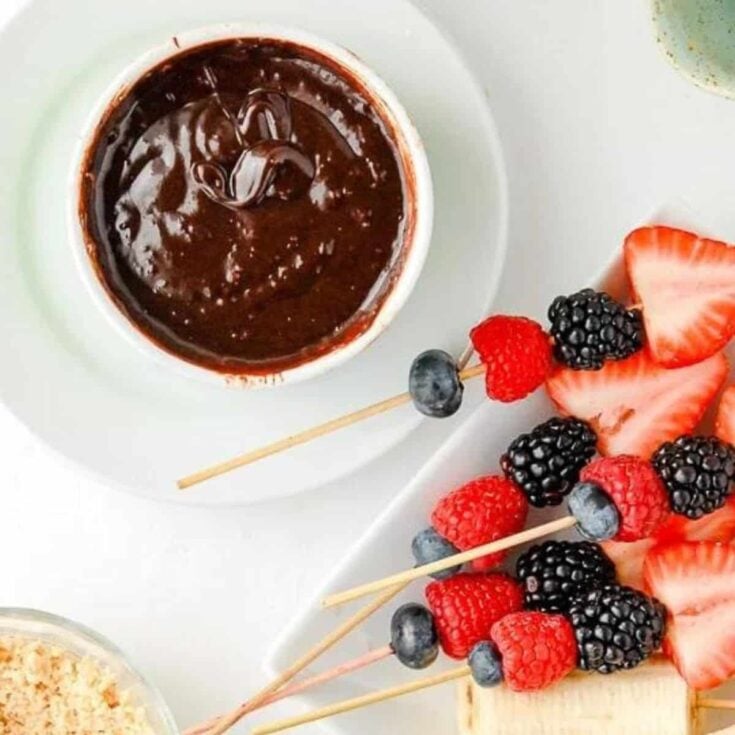 Chocolate fondue with berry skewers on the side, prepared after reading these Easy fondue recipes