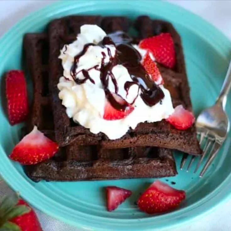 Chocolate oatmeal waffle topped with whipped cream and strawberries, made after reading these Wonderful waffle recipes