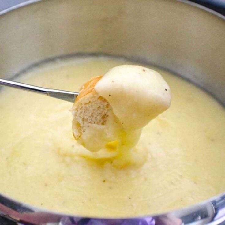 A slice of bread dipped on a classic cheese fondue after reading these Easy fondue recipes