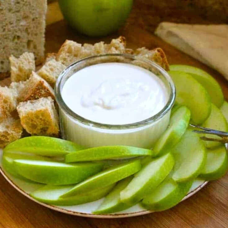 Goat cheese fondue surrounded by bread and green apple slices, prepared after reading these Easy fondue recipes