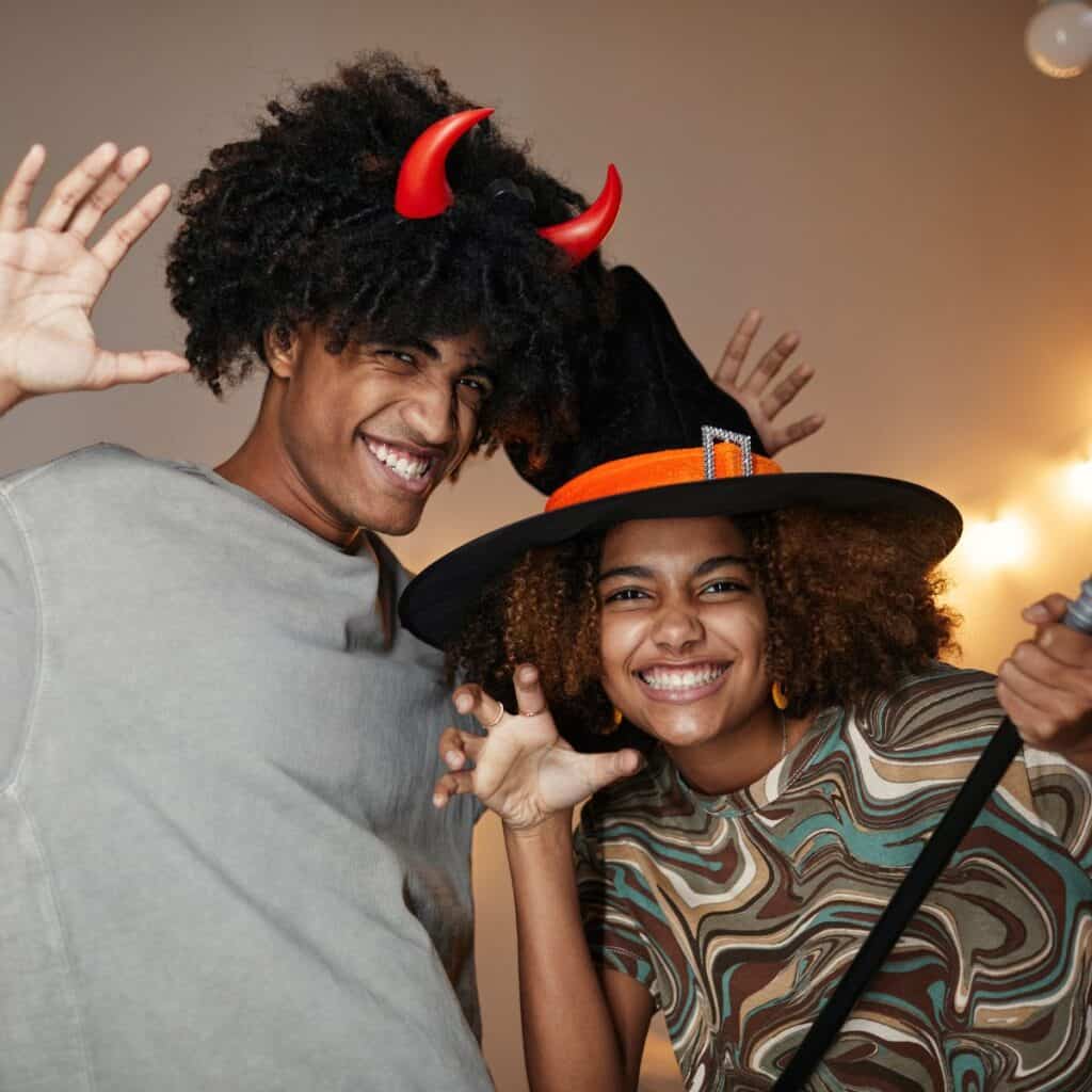 Teen couple in their cute Halloween costumes silly posing for the camera, after reading these fall date ideas for teens